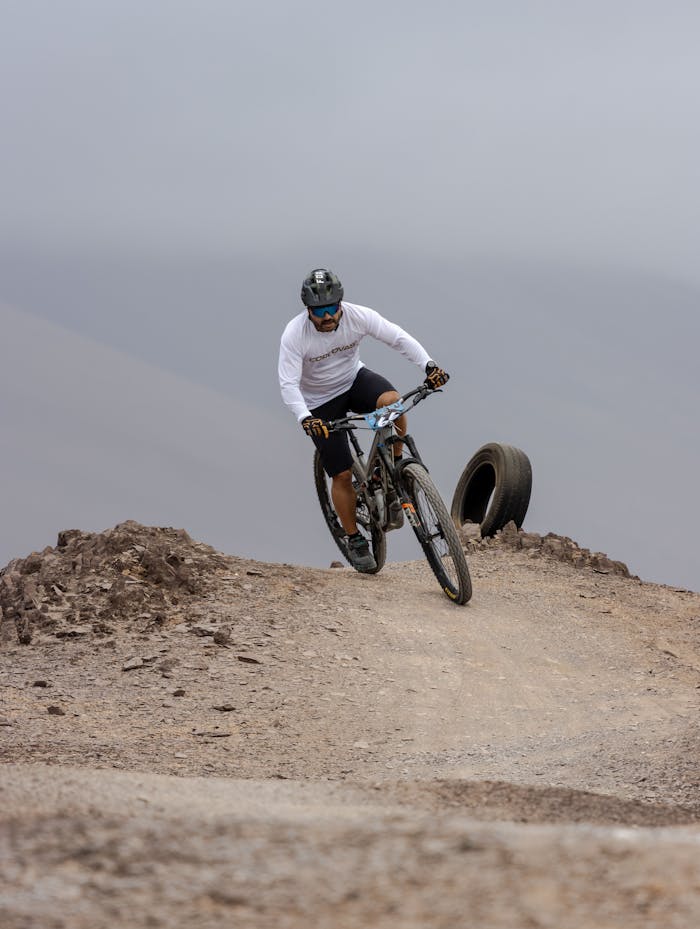 A man on a mountain bike navigating a rough terrain trail outdoors.